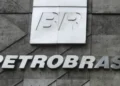 Logo BR em placa branca e letreiro Petrobras em fachada de concreto com formas geométricas