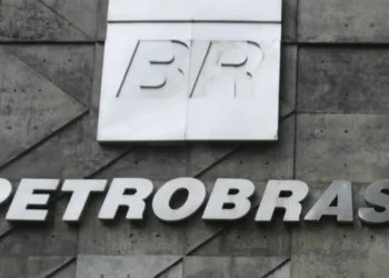 Logo BR em placa branca e letreiro Petrobras em fachada de concreto com formas geométricas