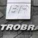 Logo BR em placa branca e letreiro Petrobras em fachada de concreto com formas geométricas