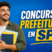 Jovem sorridente de camisa verde e cabelos cacheados segura cadernos coloridos, ao lado de texto sobre concurso Prefeitura em SP