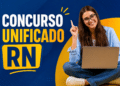 Jovem sorridente de óculos com notebook no colo e dedo levantado ao lado do texto Concurso Unificado RN