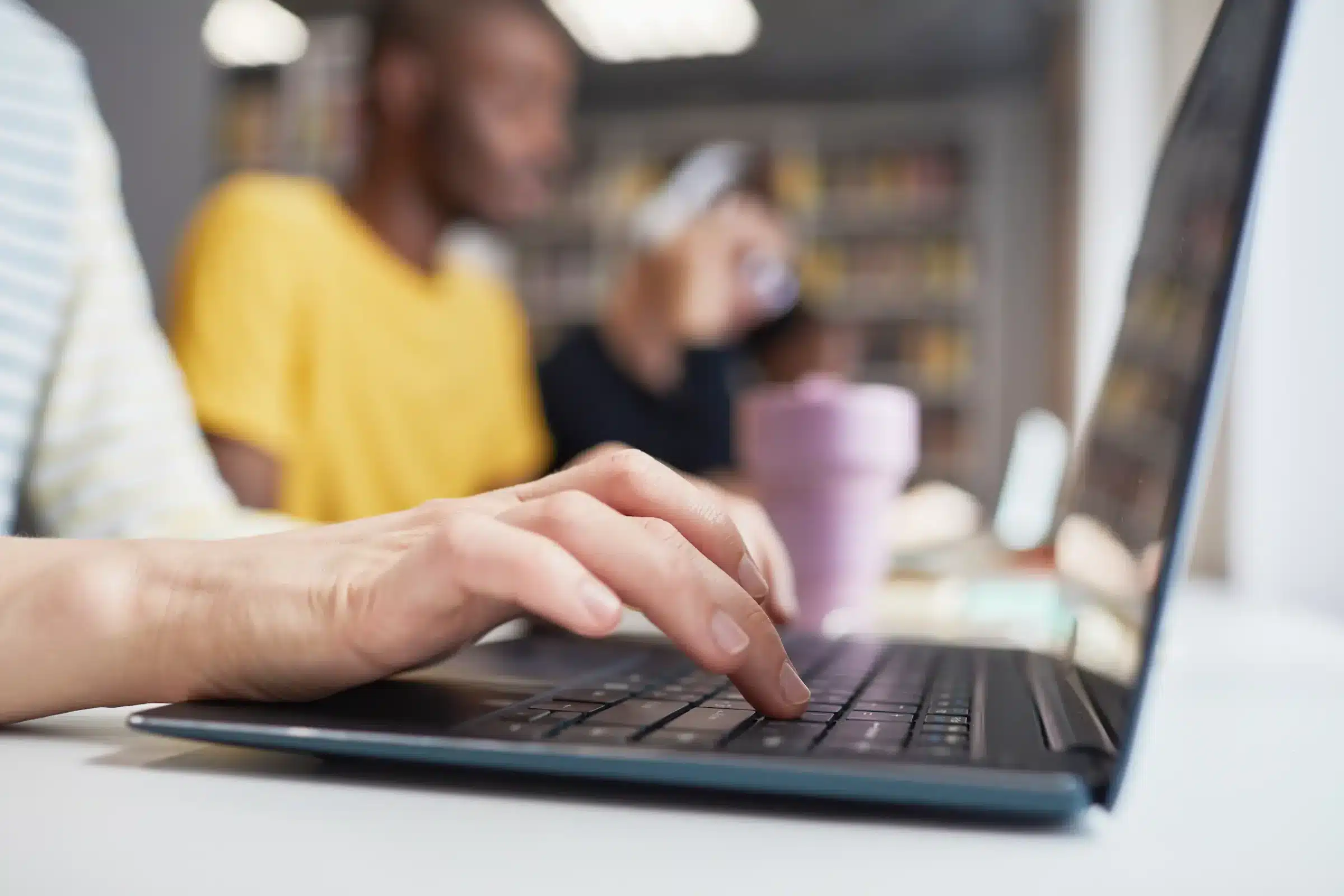 essoa digitando no teclado de um laptop, representando a preparação para os concursos públicos com mais de 1.500 vagas disponíveis.