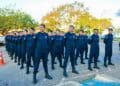 Guardas municipais perfilados em rua usando uniforme azul-marinho, boinas e coturnos durante formatura