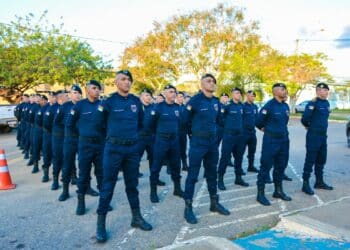 Guardas municipais perfilados em rua usando uniforme azul-marinho, boinas e coturnos durante formatura