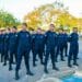 Guardas municipais perfilados em rua usando uniforme azul-marinho, boinas e coturnos durante formatura