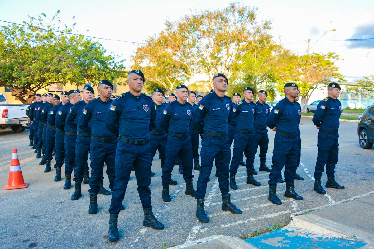 Guardas municipais perfilados em rua usando uniforme azul marinho, boinas e coturnos, com brasões nos braços
