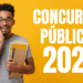 Jovem de óculos segurando cadernos sorri surpreso ao lado do texto “Concursos Públicos 2026” sobre fundo amarelo