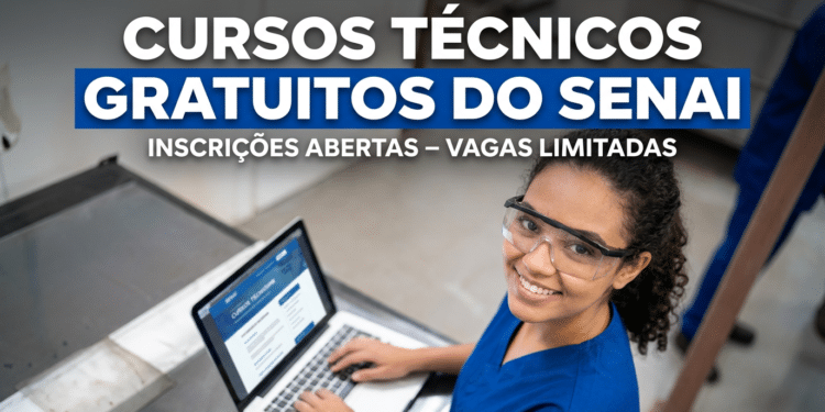Estudante sorridente usando óculos de proteção e uniforme azul opera notebook em laboratório do SENAI