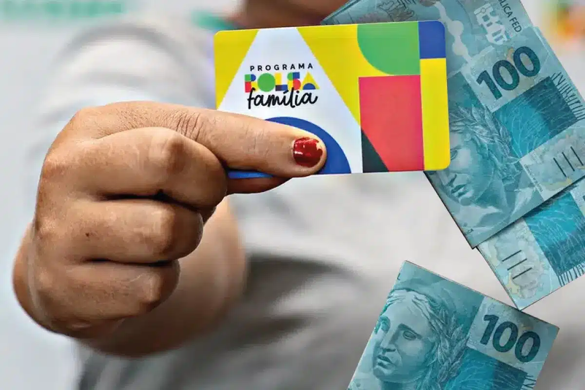 Cartão do Bolsa Família com cédulas de real ilustrando o calendário de pagamentos de maio de 2026