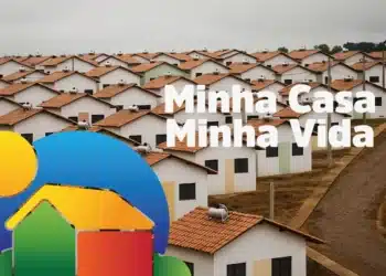 Vista aérea de casas do programa Minha Casa Minha Vida, com telhados vermelhos e a logo do programa ao lado.