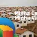 Vista aérea de casas do programa Minha Casa Minha Vida, com telhados vermelhos e a logo do programa ao lado.