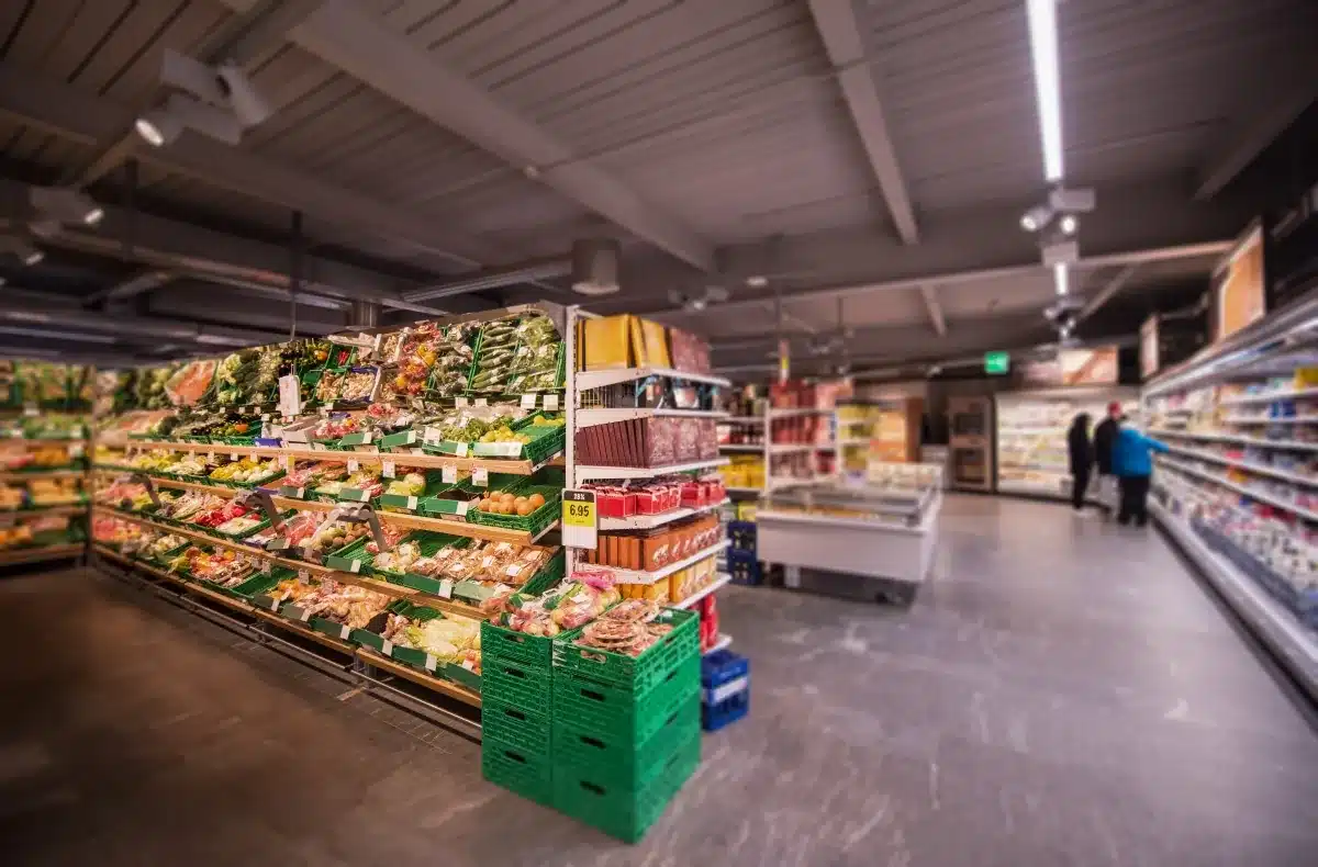 Interior de supermercado com hortifrúti e corredores organizados, representando um dos estabelecimentos abertos durante o feriado