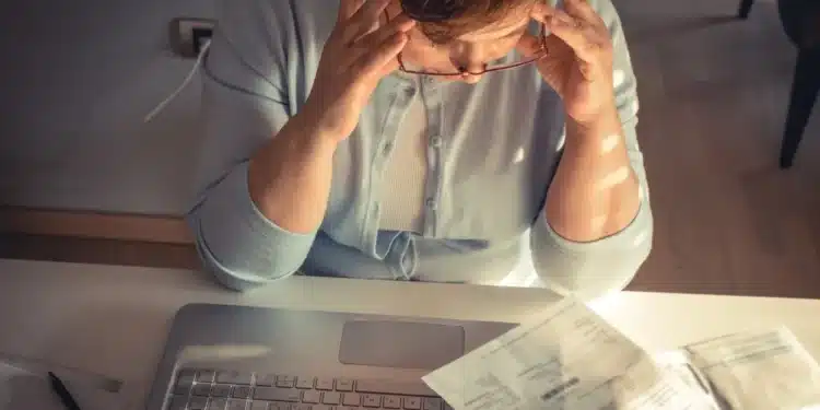Pessoa preocupada analisando conta de luz no computador após possível golpe com empréstimo em seu nome