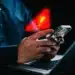 Pessoa usando celular com alerta de golpe digital relacionado a mensagens suspeitas no WhatsApp.