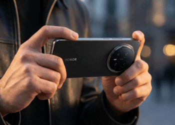 Mãos segurando smartphone Honor Magic9 preto com módulo de câmeras circular e quatro lentes visíveis em ambiente urbano