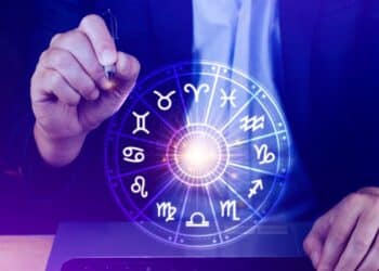 Roda dos signos do zodíaco iluminada com símbolos astrológicos representando as previsões do horóscopo para abril de 2026.