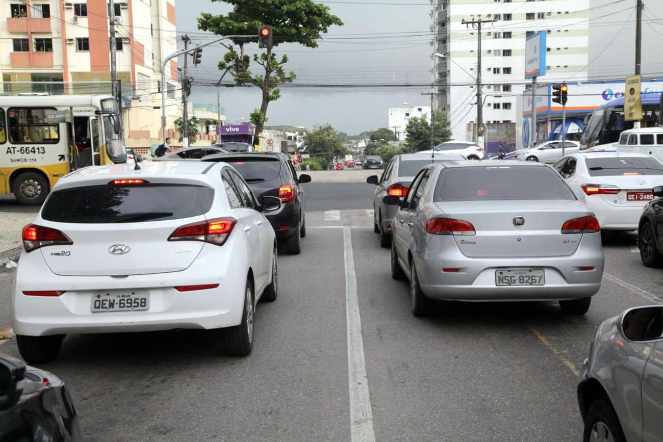 Veículos parados em semáforo vermelho em avenida de Belém, com Hyundai HB20 branco e Fiat prata em destaque