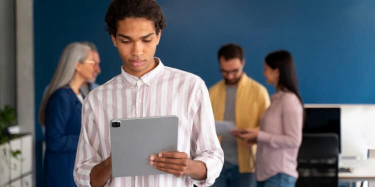 Dois profissionais analisam uma representação gráfica de cérebro artificial em um monitor, ilustrando o avanço da inteligência artificial no mercado de trabalho.