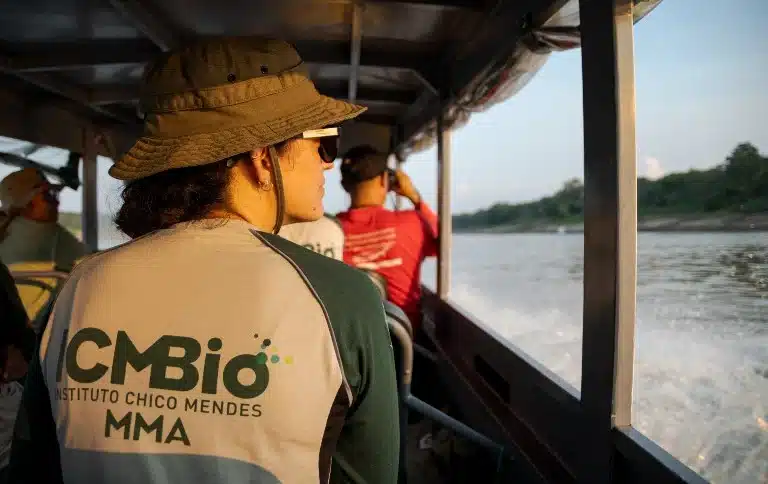 Servidora do ICMBio vestindo camisa oficial com a logomarca do Instituto Chico Mendes durante deslocamento em embarcação fluvial