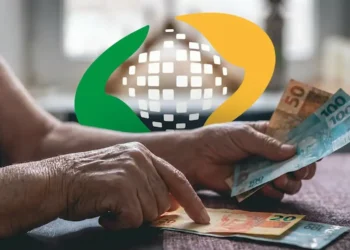 Aposentado recebendo pagamento do INSS em notas de R$ 100, R$ 50 e R$ 20, com o logo do INSS em fundo borrado.