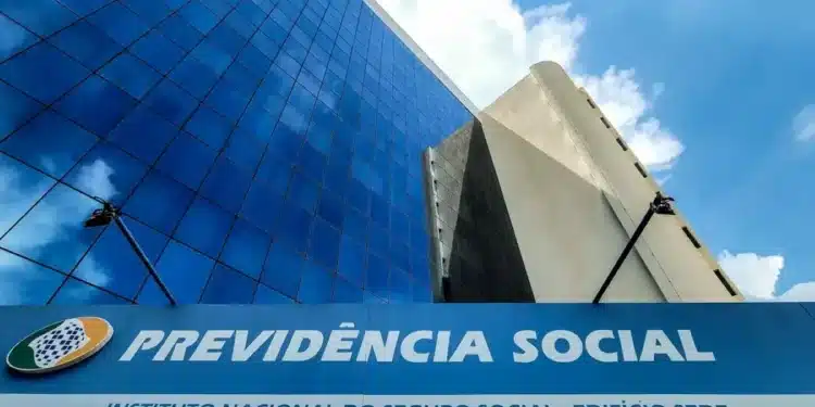 Prédio do INSS com fachada espelhada e placa Previdência Social representando fechamento temporário das agências no Brasil