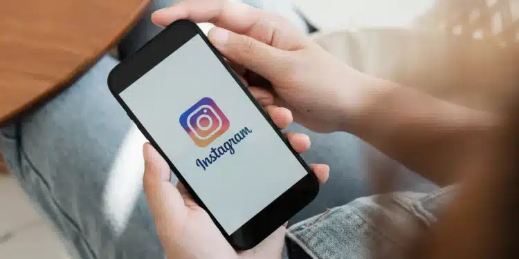 Pessoa segurando smartphone com o logo do Instagram na tela, ilustrando o lançamento do 'Instants'.