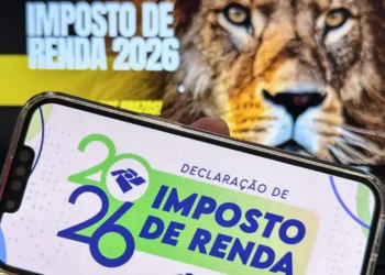 Declaração do Imposto de Renda 2026 exibida em celular com símbolo do leão ao fundo.