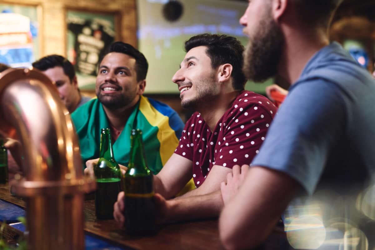 Torcedores brasileiros assistindo jogo do Brasil na Copa do Mundo 2026 em bar