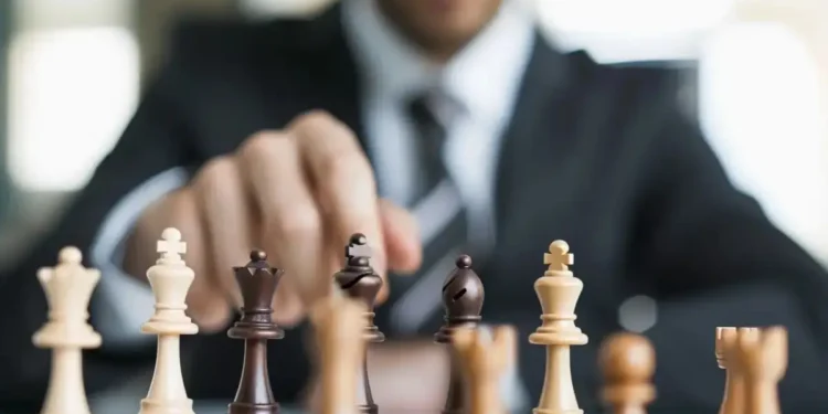 Homem de negócios movimentando peça de xadrez representando tomada de decisão e liderança estratégica