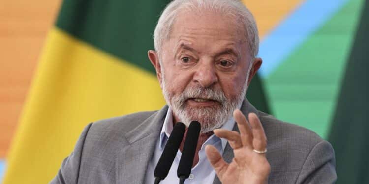 Presidente Lula discursando em evento com bandeira do Brasil ao fundo sobre proposta do Pé-de-Meia para universitários