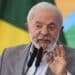 Presidente Lula discursando em evento com bandeira do Brasil ao fundo sobre proposta do Pé-de-Meia para universitários