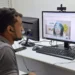 Homem participando de mutirão do INSS para perícia médica, assistindo a uma videoconferência.