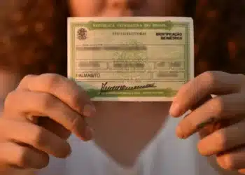 Eleitora segura título eleitoral em destaque durante período de regularização junto à Justiça Eleitoral.