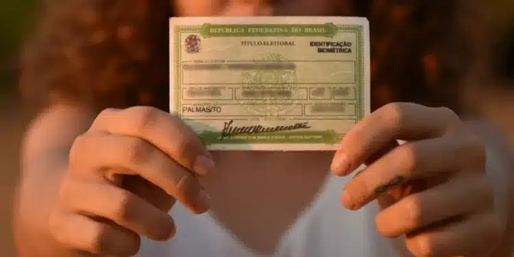 Eleitora segura título eleitoral em destaque durante período de regularização junto à Justiça Eleitoral.