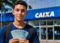 Estudante segura dinheiro em frente a uma agência da Caixa em referência aos pagamentos do Pé-de-Meia de agosto.