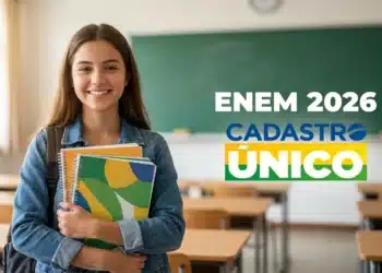 Estudante sorridente segurando cadernos em sala de aula com referência à isenção da taxa do Enem 2026 para participantes do CadÚnico.