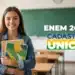 Estudante sorridente segurando cadernos em sala de aula com referência à isenção da taxa do Enem 2026 para participantes do CadÚnico.