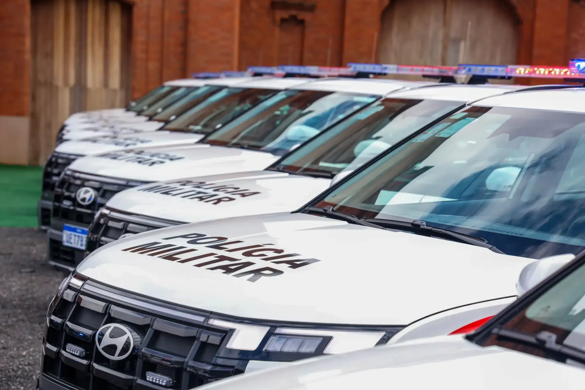 Viaturas da Polícia Militar de São Paulo alinhadas em frente a quartel.