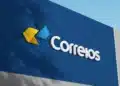 Letreiro 3D dos Correios em fachada azul com símbolo de setas amarela e azul e logotipo branco
