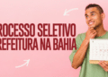 Jovem de camiseta verde segura calendário de setembro 2021 com datas marcadas em X ao lado de texto sobre processo seletivo na Bahia