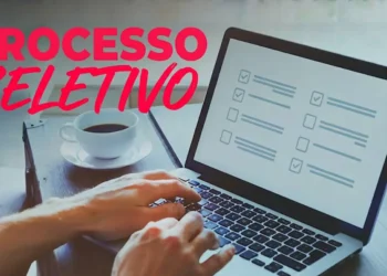 Profissional utilizando notebook para inscrição em processo seletivo da Secretaria de Saúde com vagas abertas.