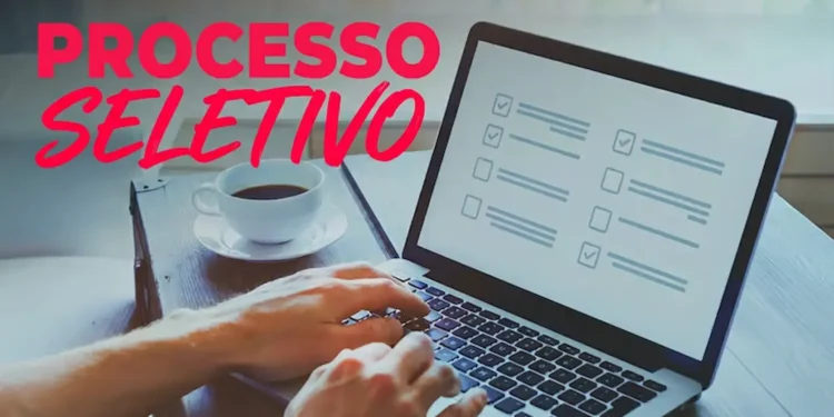 Profissional utilizando notebook para inscrição em processo seletivo da Secretaria de Saúde com vagas abertas.