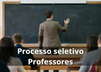 Professor escrevendo em quadro em sala de aula durante processo seletivo público.