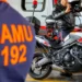 Profissional do SAMU em motolância equipada para atendimento pré-hospitalar , ao lado de uniforme laranja com inscrição SAMU 192.