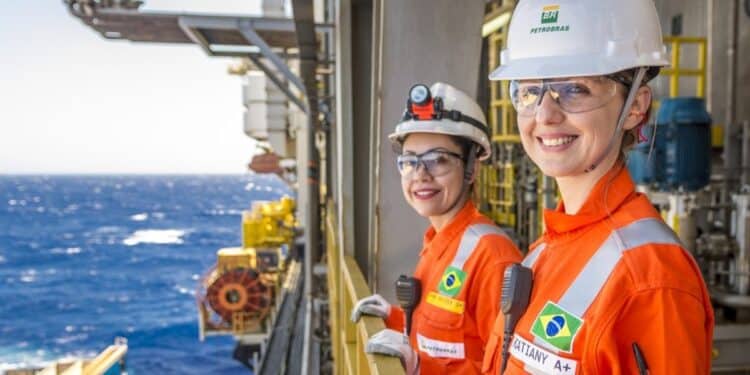 Duas mulheres com uniforme laranja e capacete da Petrobras em plataforma offshore — concurso Petrobras
