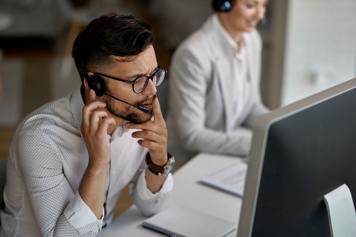 Profissional de call center em atendimento ao cliente, representando as mudanças nas funções do mercado de trabalho, onde profissões operacionais estão sendo substituídas por novas funções ligadas à tecnologia e análise de dados.