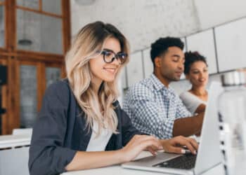 Jovens estagiários trabalhando em notebook no escritório — estagiários podem ganhar salário mínimo com novo projeto de lei 2026