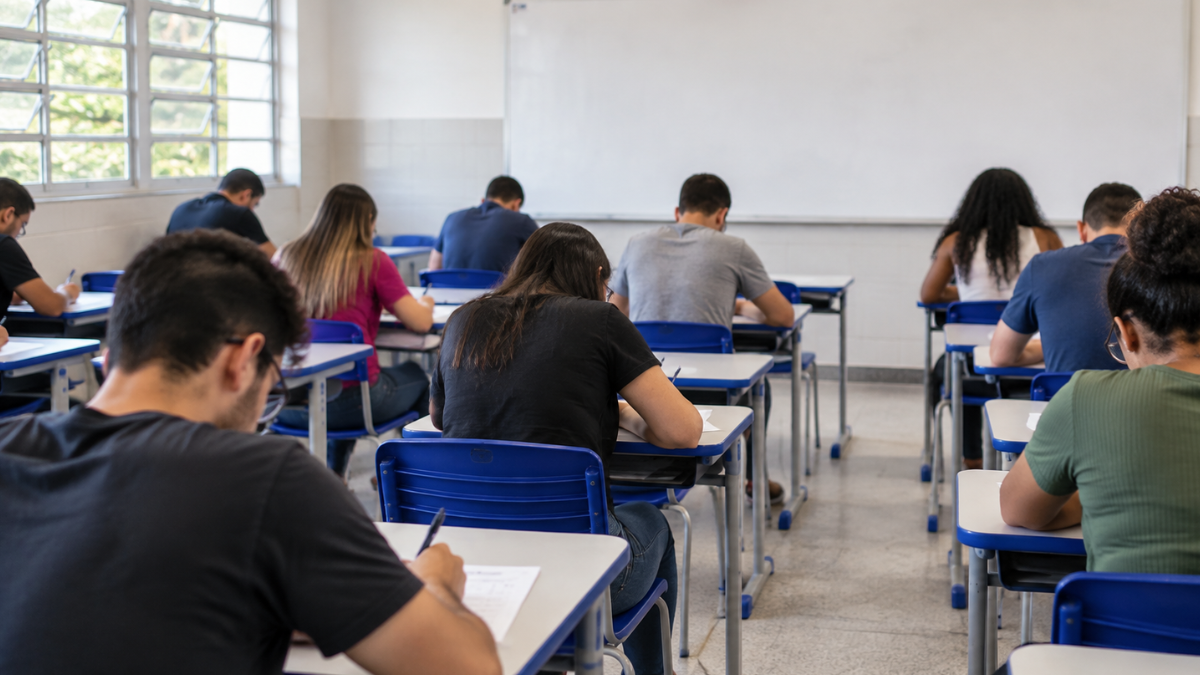 Candidatos realizam prova de concurso público em sala de aula para seleção da Câmara dos Deputados.