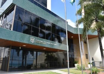Concurso TCE RN 2026 - fachada do Tribunal de Contas do Estado do Rio Grande do Norte com bandeiras e palmeiras