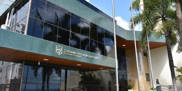 Concurso TCE RN 2026 - fachada do Tribunal de Contas do Estado do Rio Grande do Norte com bandeiras e palmeiras